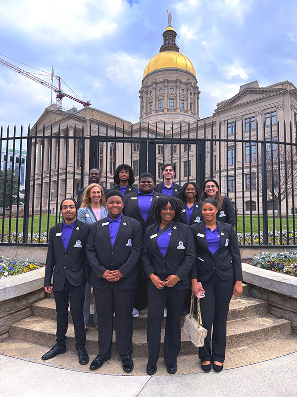 Members of the President's Torch Society pose in their official uniforms in front of the Georgia State Capitol.